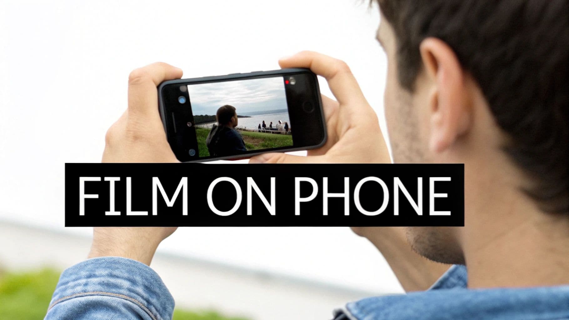 A person holds a smartphone horizontally, filming a scenic view of people by the water, with 'FILM ON PHONE' overlay.